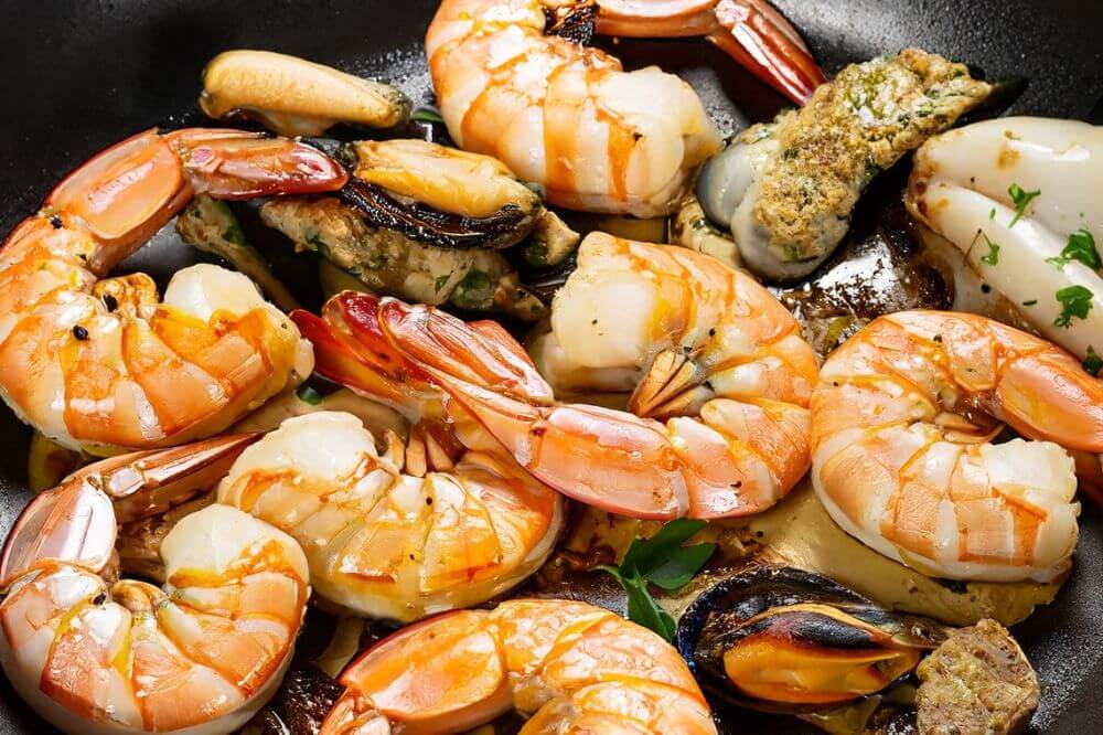 Photo haute définition d'une poêlée de fruits de mer préparé avec une plancha gaz en inox de Euskal Plantxa